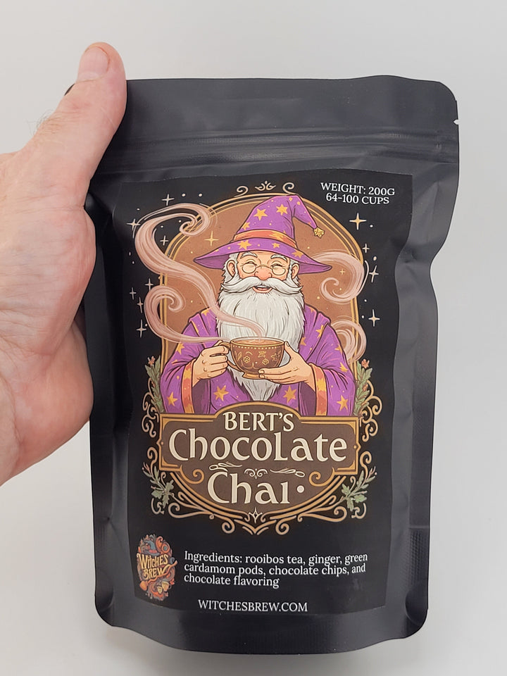 Hand holding a package of Bert's Chocolate Chai on a light gray background