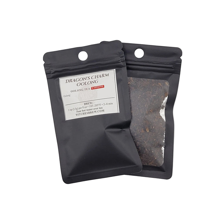 Two black tea packages with visible tea leaves on a light gray background