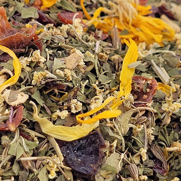 Close-up of a mix of dried herbs and flowers with visible colors including yellow, purple, and green.