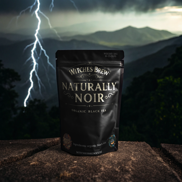 Witches Brew Naturally Noir tea bag with a lightning strike and mountain background