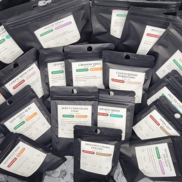 Multiple small 10g tea bags from witches brew tea with labels on a dark surface